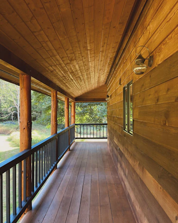 A porch with a wooden floor and railing