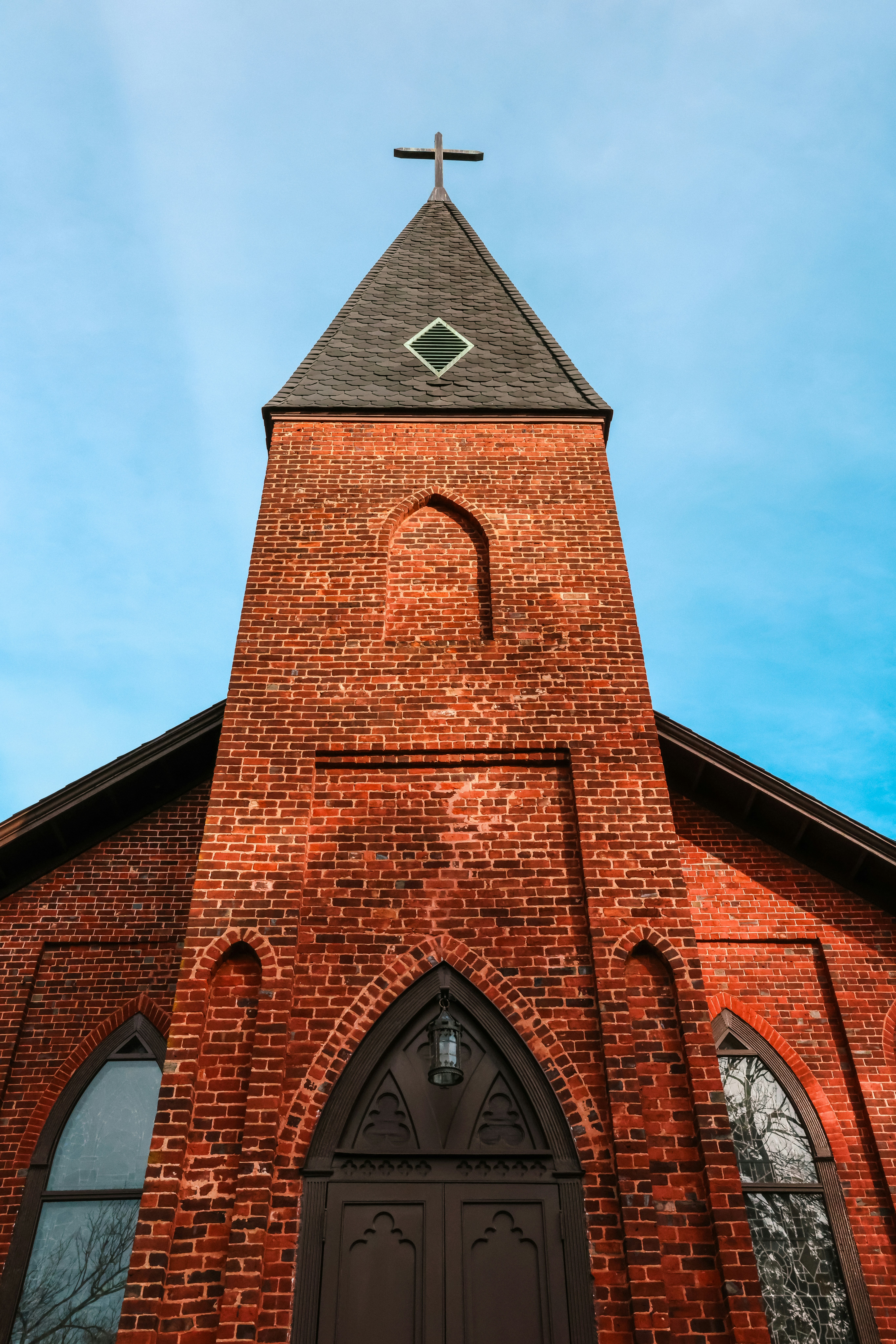 Eine hohe Backsteinkirche mit einem Kreuz auf der Spitze