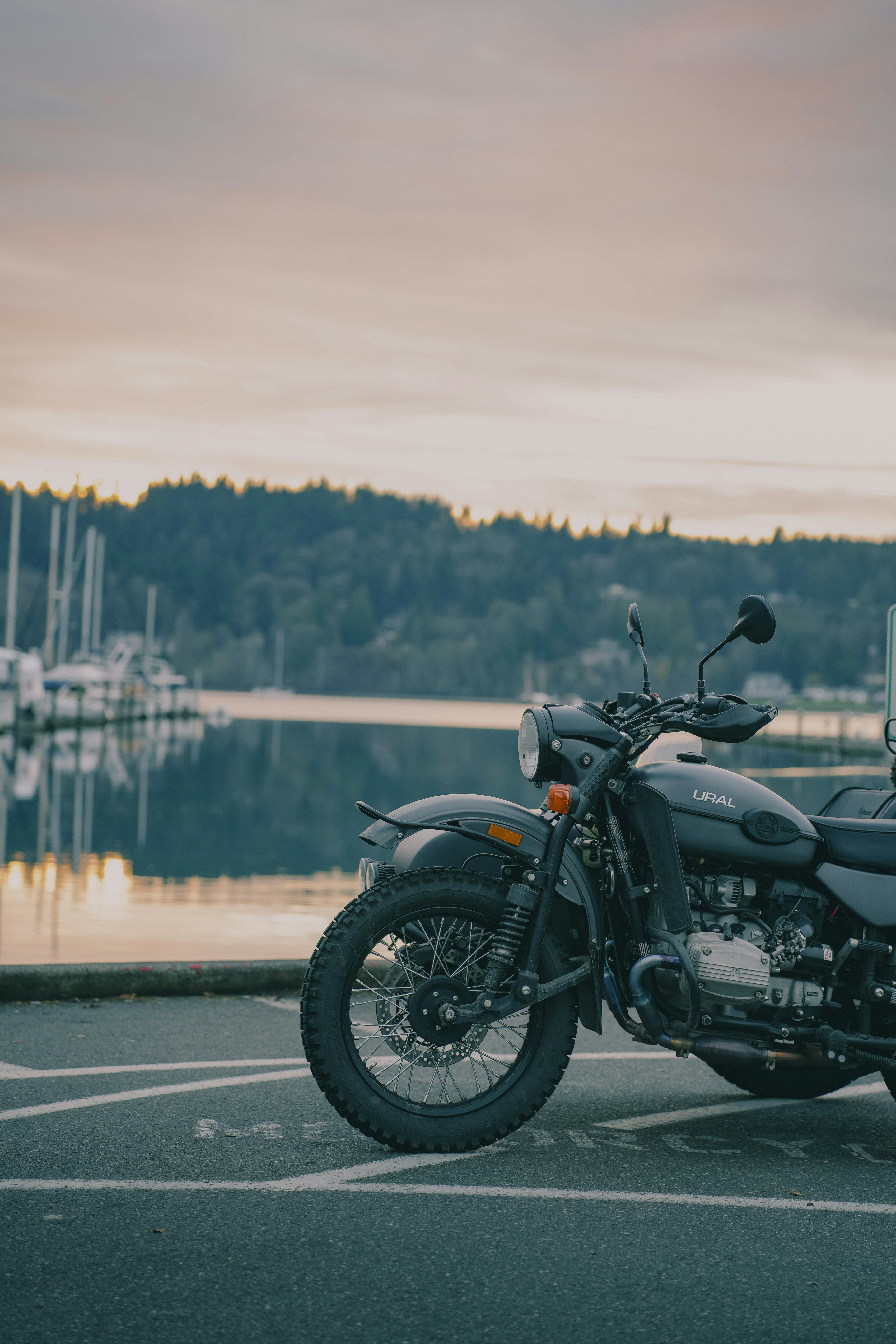 A motorcycle parked in a parking lot next to a body of water