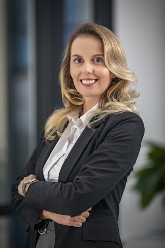 A woman in a business suit standing with her arms crossed
