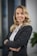 A woman in a business suit standing with her arms crossed