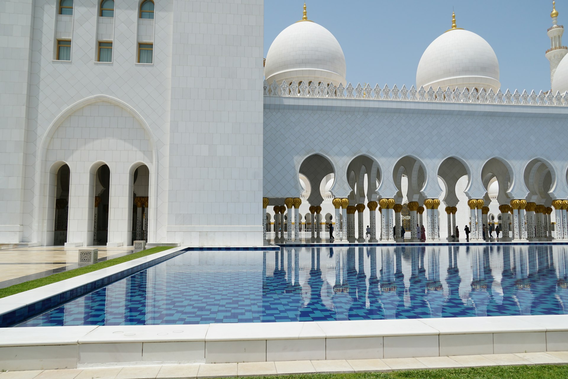 A large white building with a pool in front of it