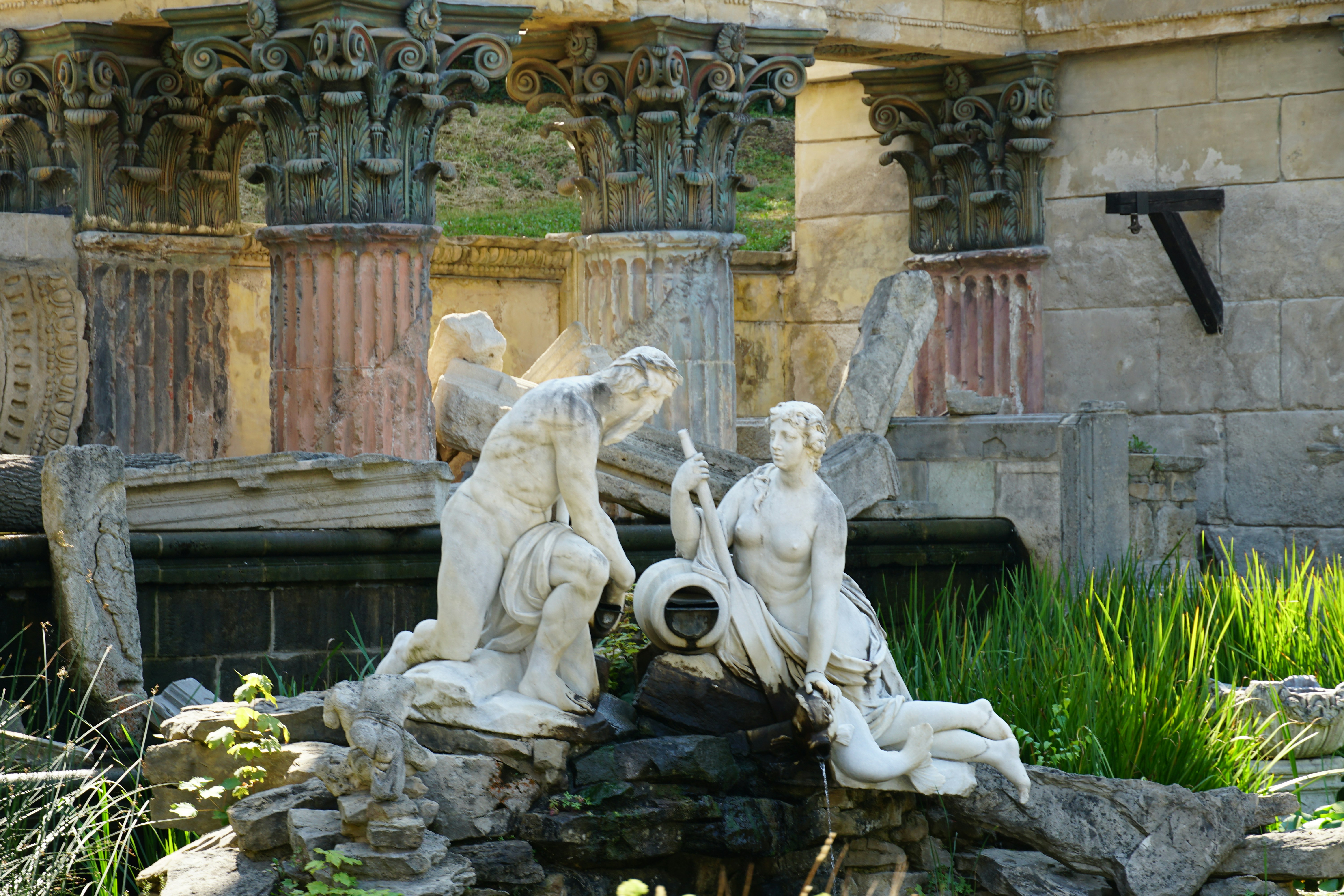 A fountain in a garden with statues around it