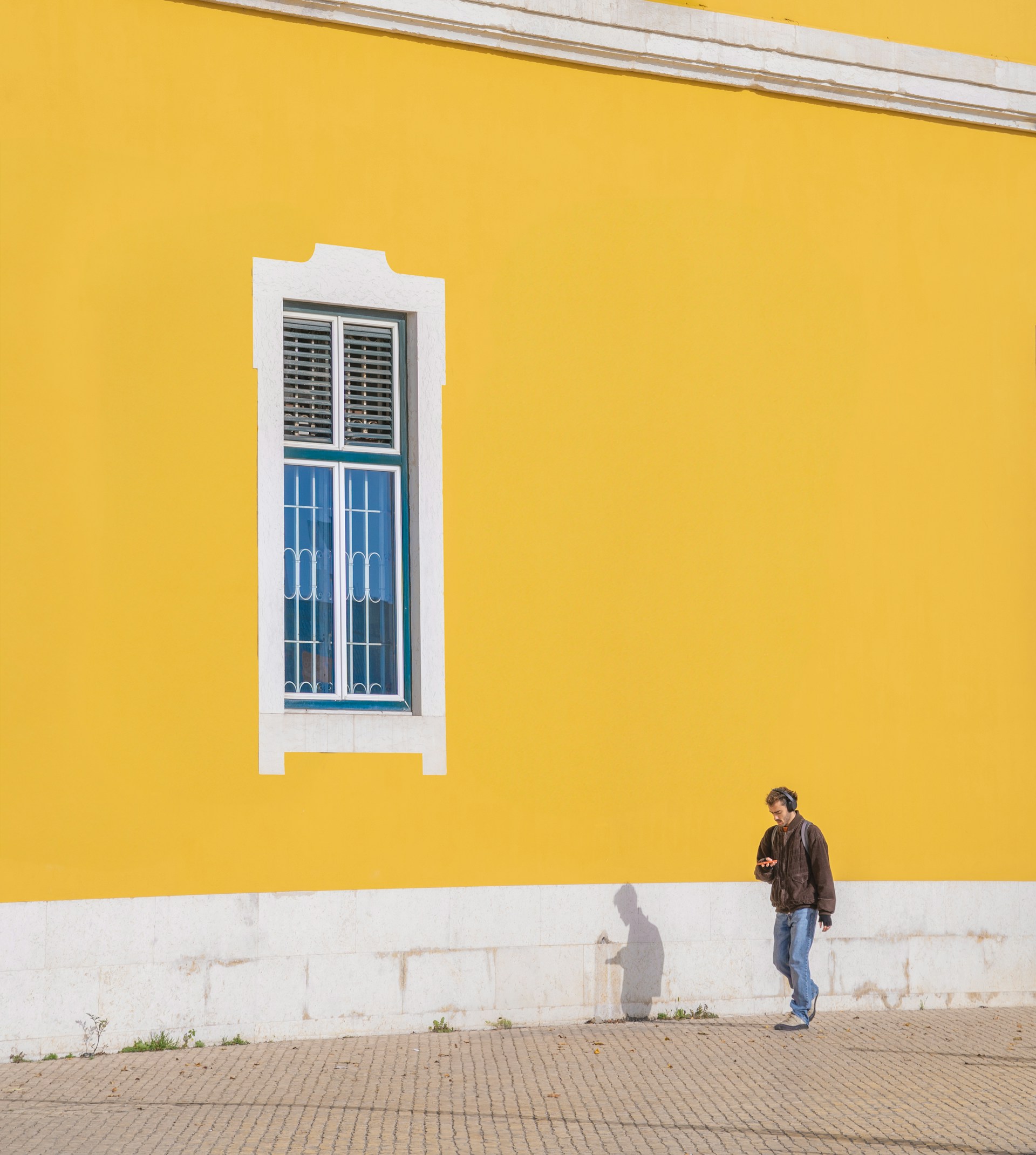 A man standing in front of a yellow building