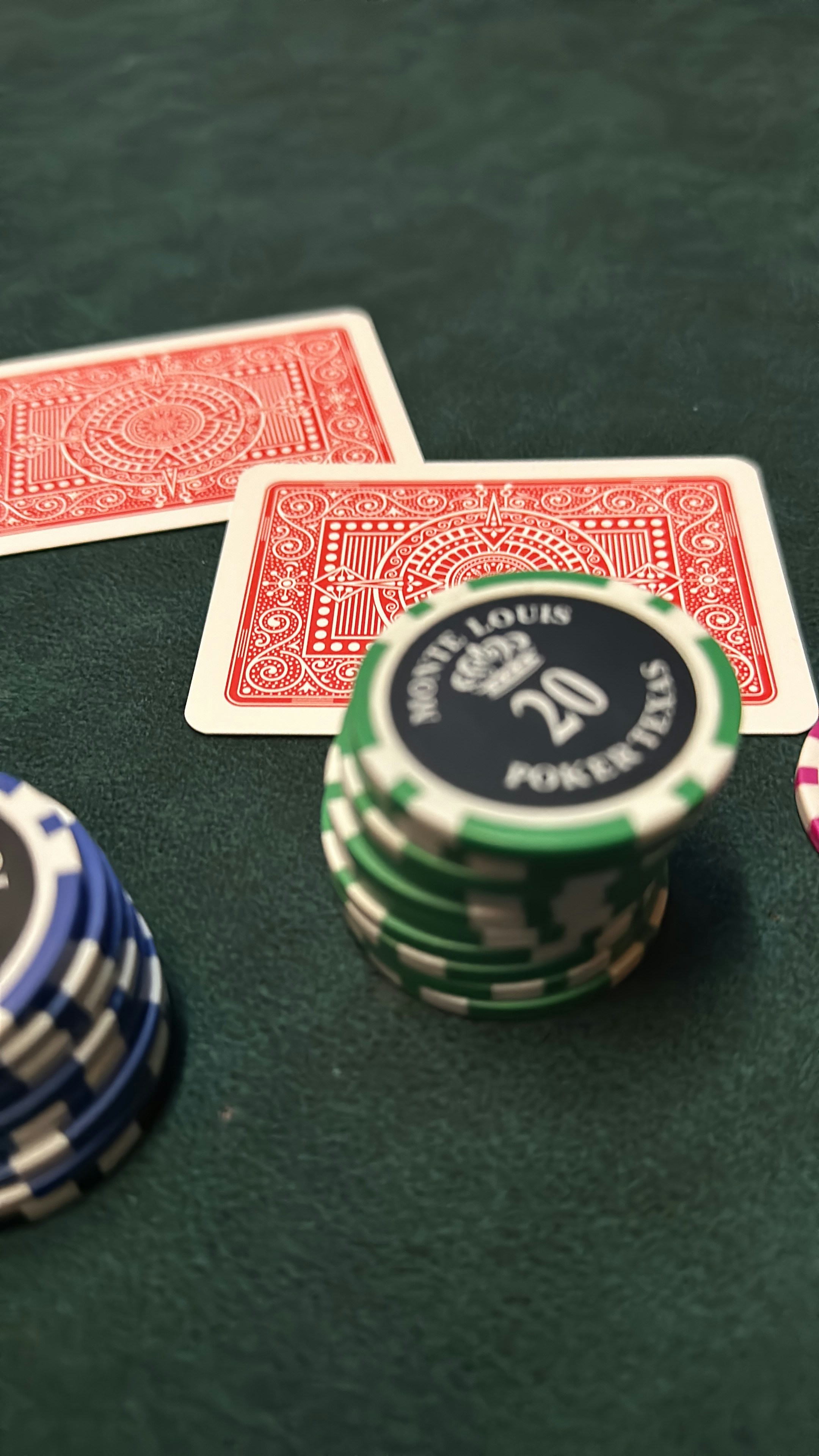 Poker chips and playing cards arranged on a green felt table
