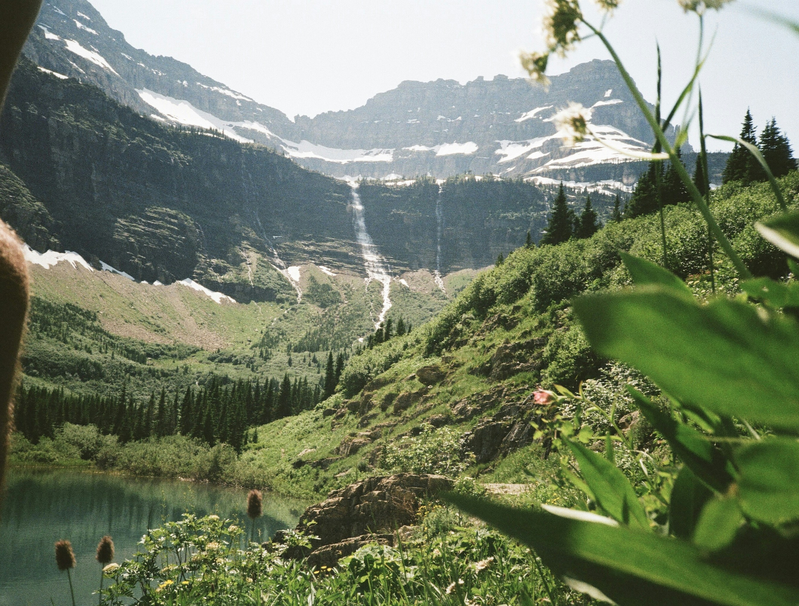 A person is taking a picture of a mountain lake