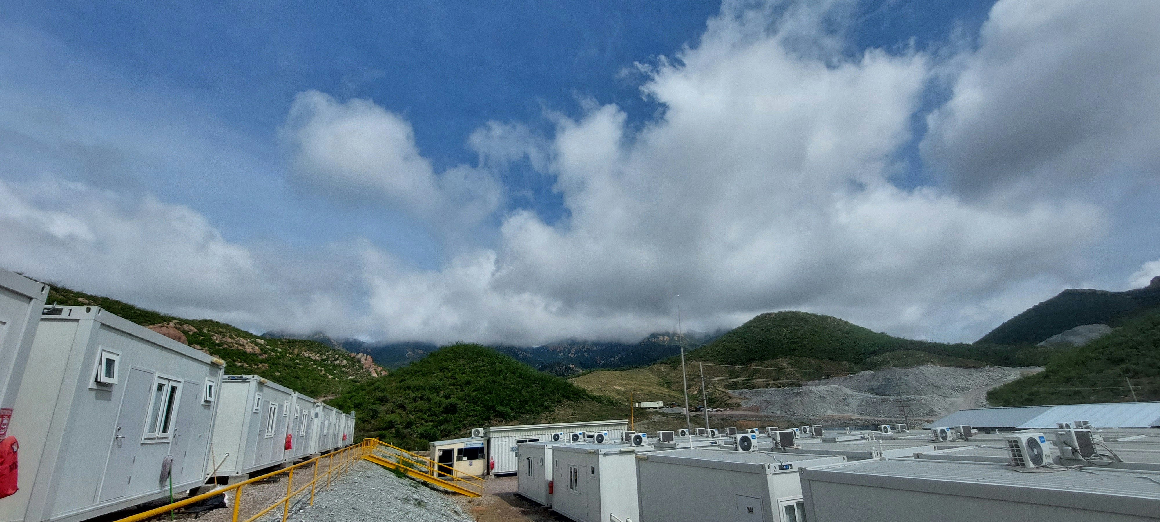 Prefabricated modular building with clean white panels and green landscaping in a rural setting