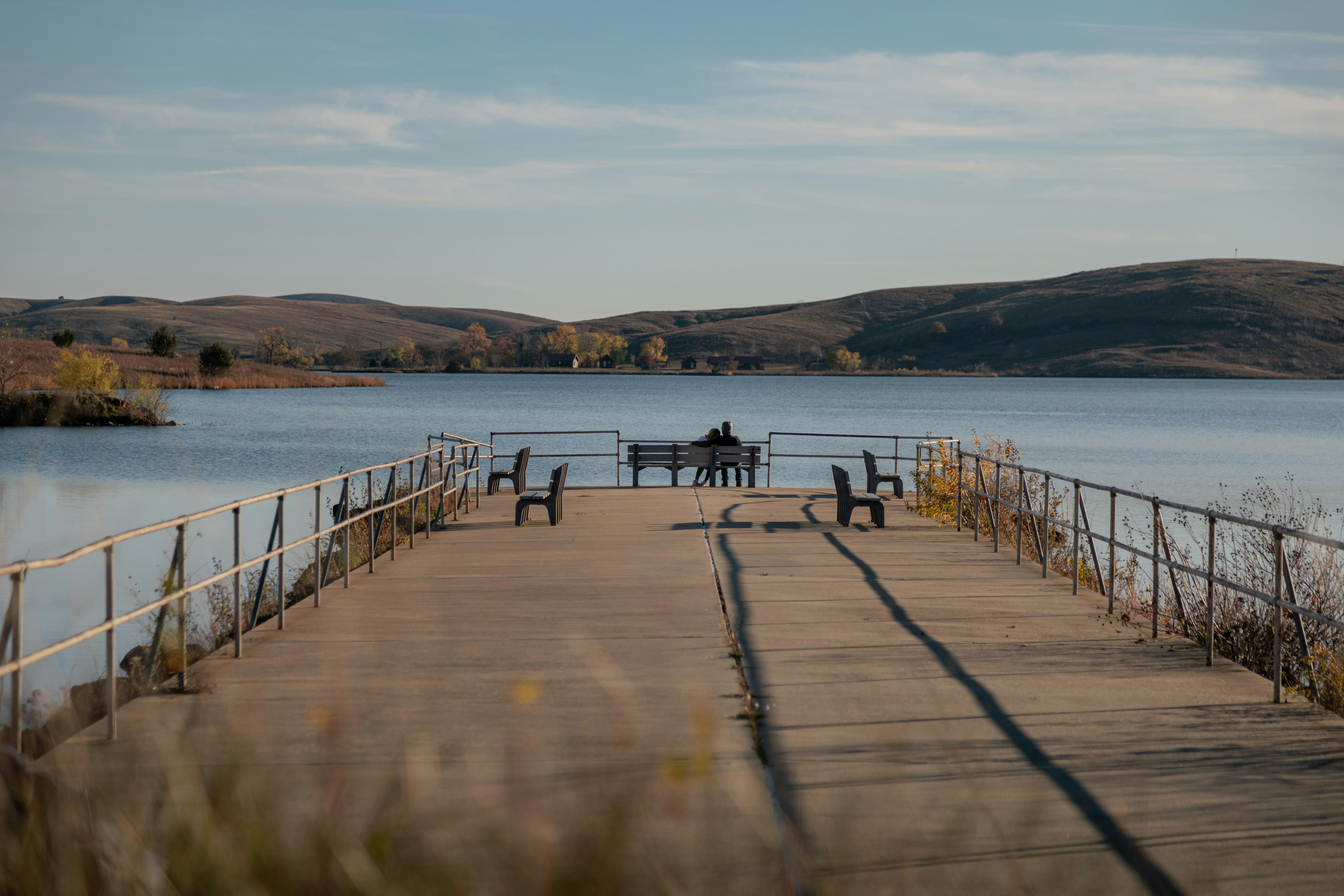 A pier with a couple of people sitting on it
