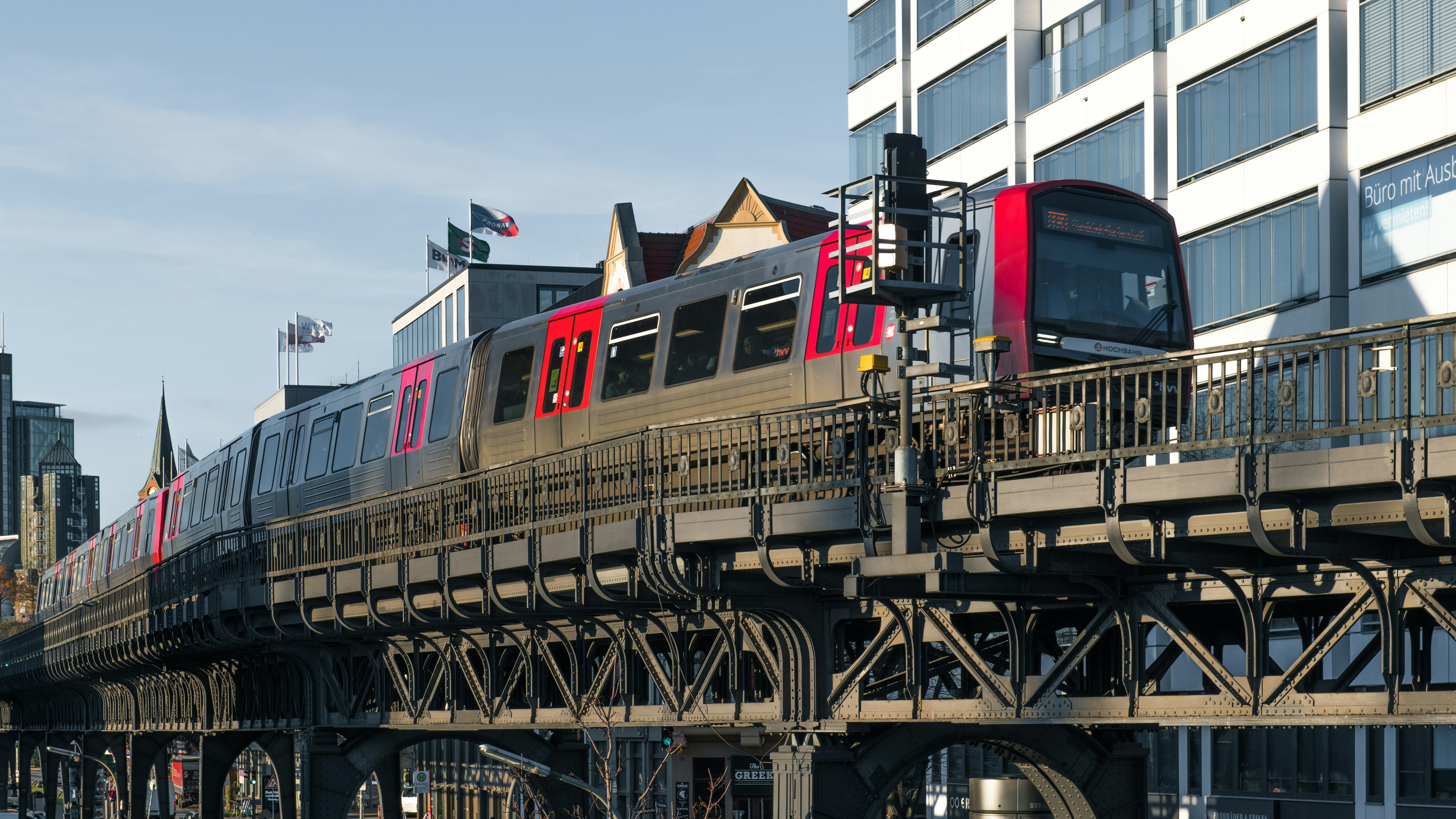 A train traveling over a bridge next to tall buildings