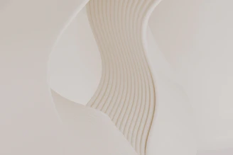 A close up of a white vase with wavy lines on it