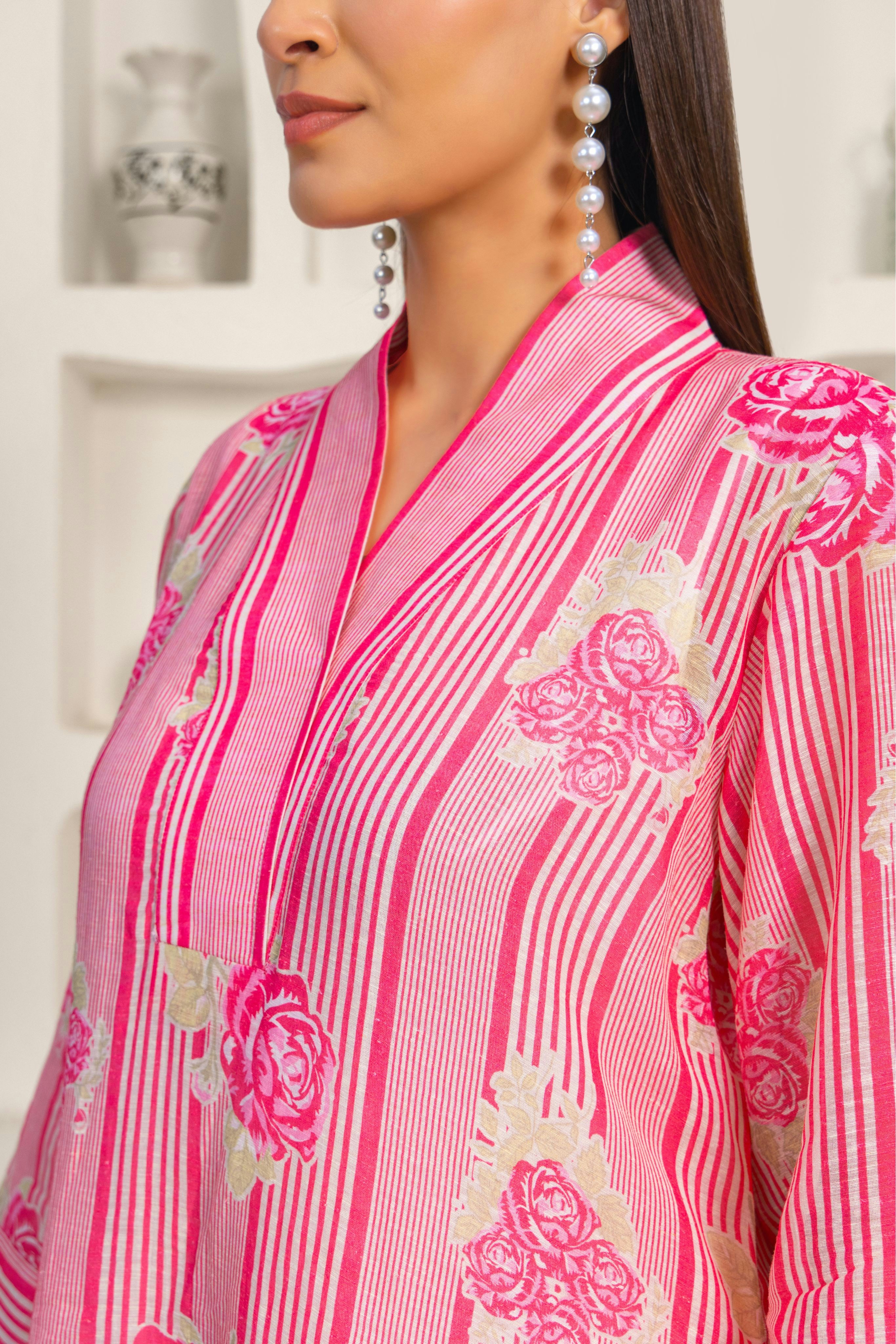 A woman wearing a pink and white shirt and earrings