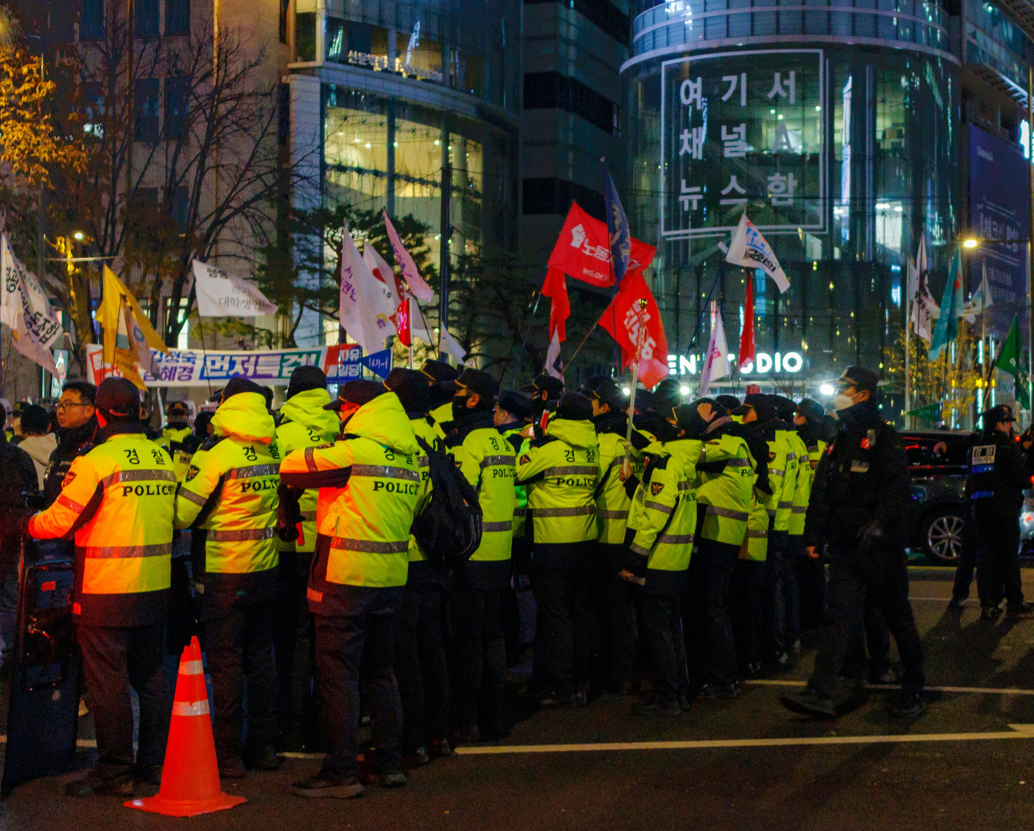 A group of police officers standing in front of a crowd of people