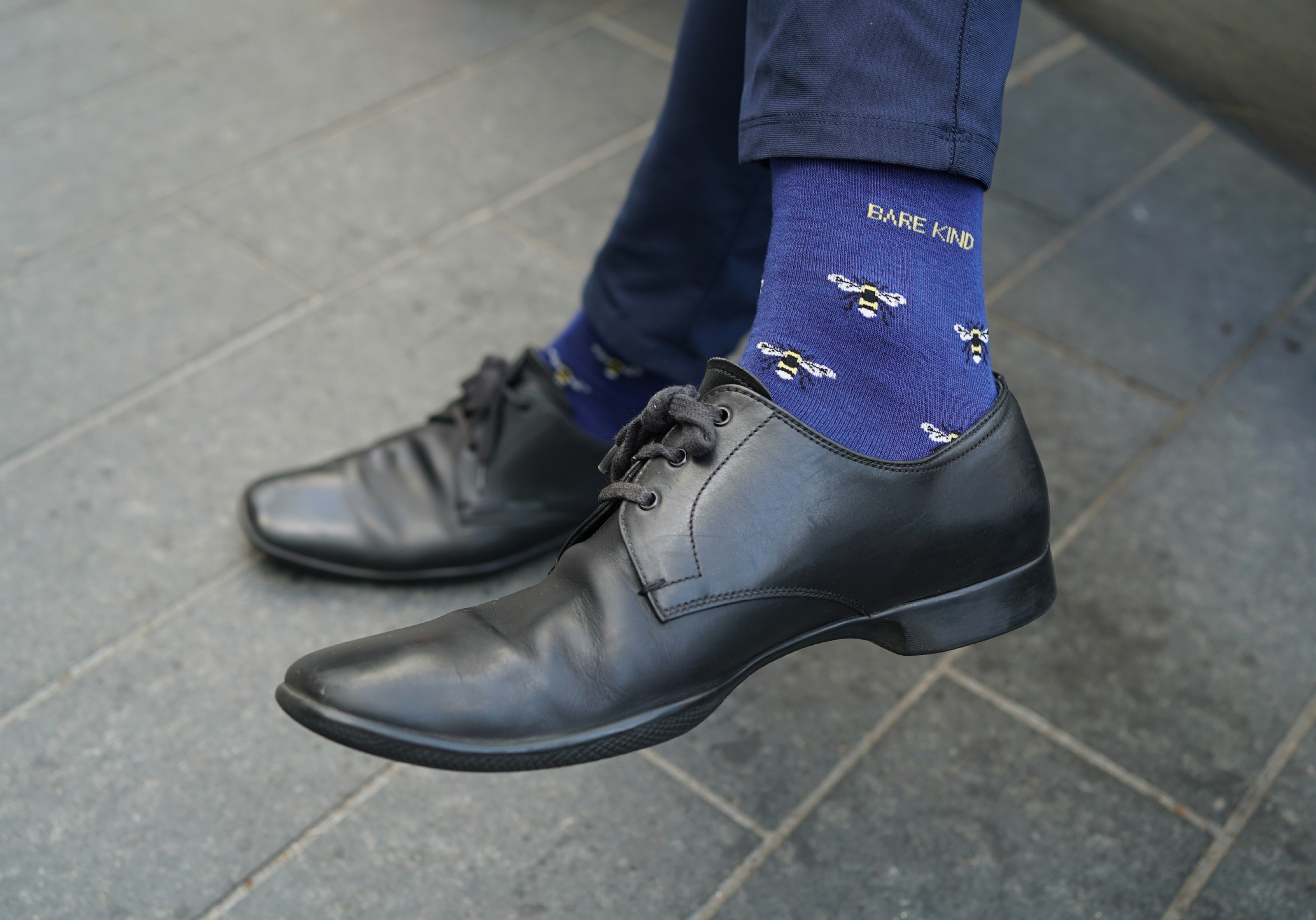 A man wearing a blue tie and black shoes