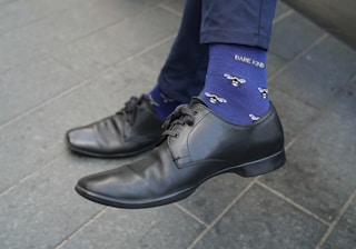 A man wearing a blue tie and black shoes