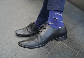 A man wearing a blue tie and black shoes