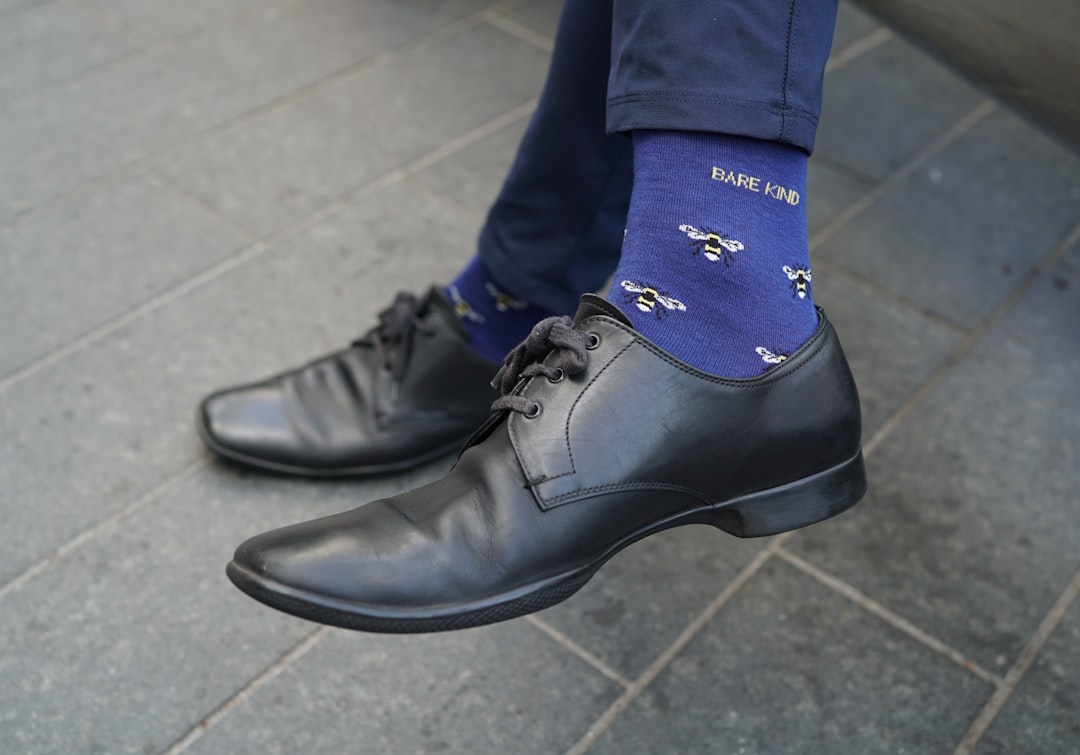 A man wearing a blue tie and black shoes