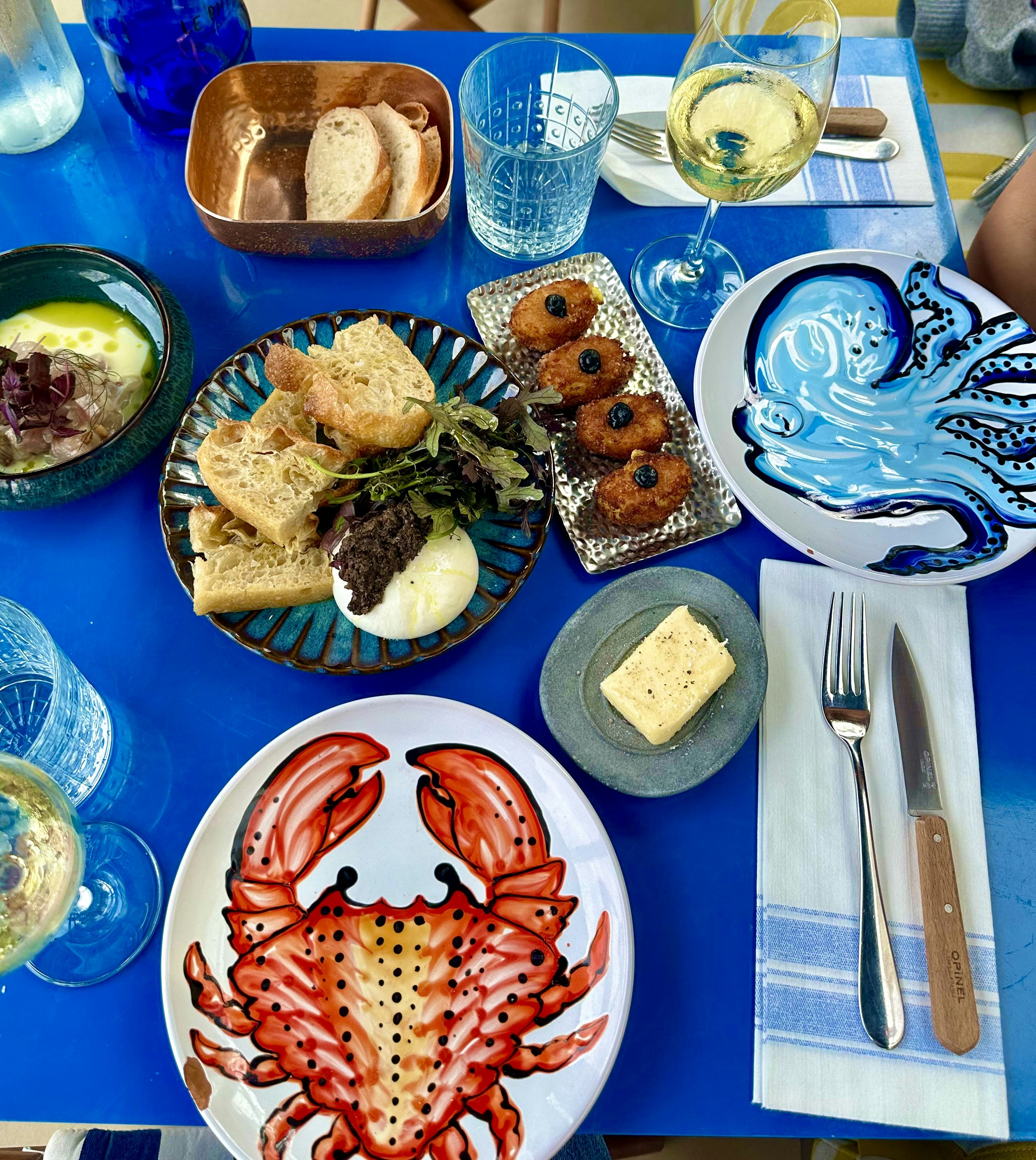 A blue table topped with plates of food