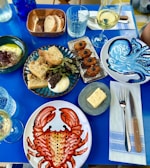 A blue table topped with plates of food