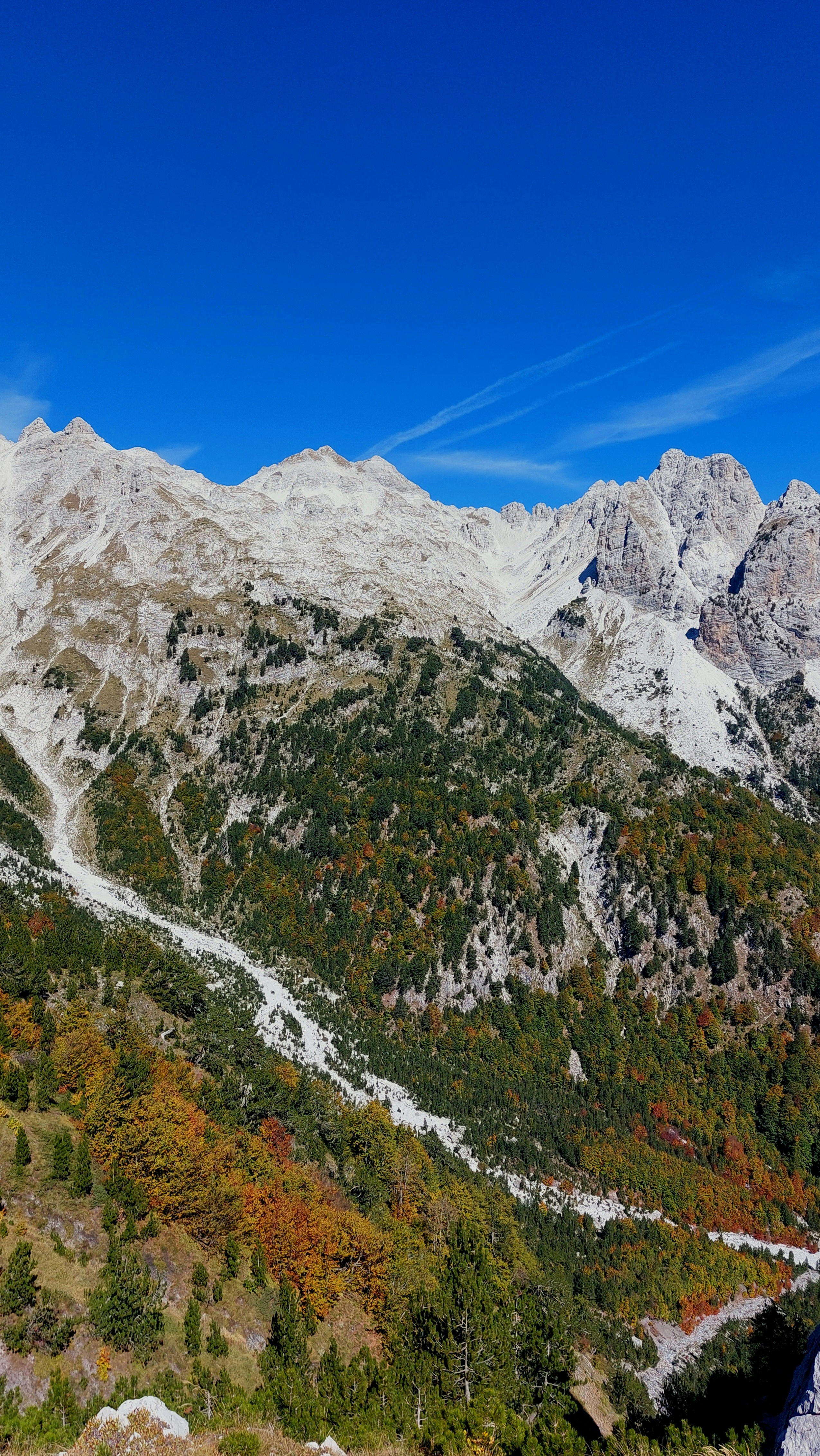 Hiker enjoying a panoramic view from a trail in the Albanian Alps