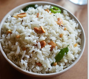 A white bowl filled with rice and nuts