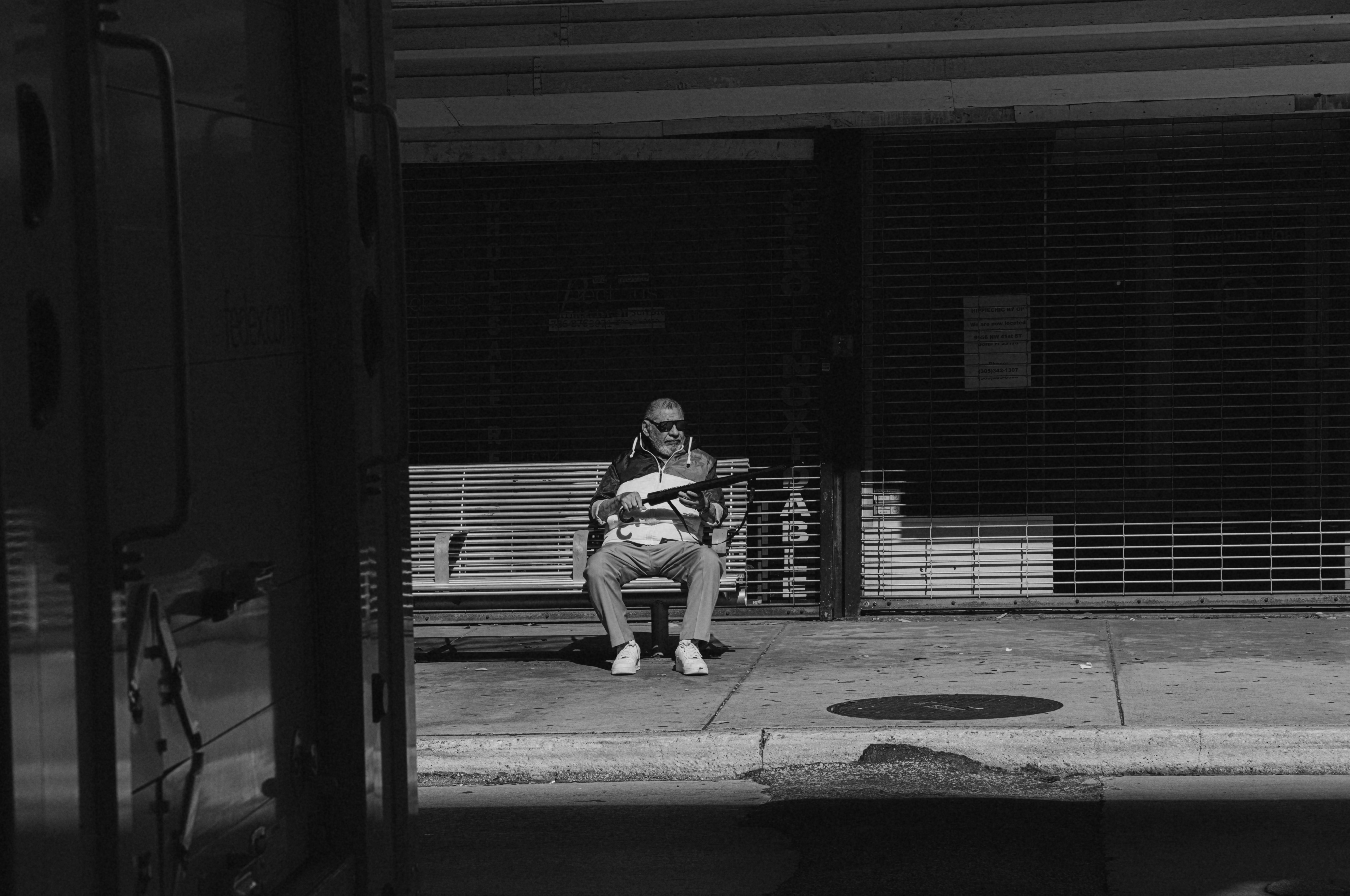 A person sitting on a bench on a sidewalk