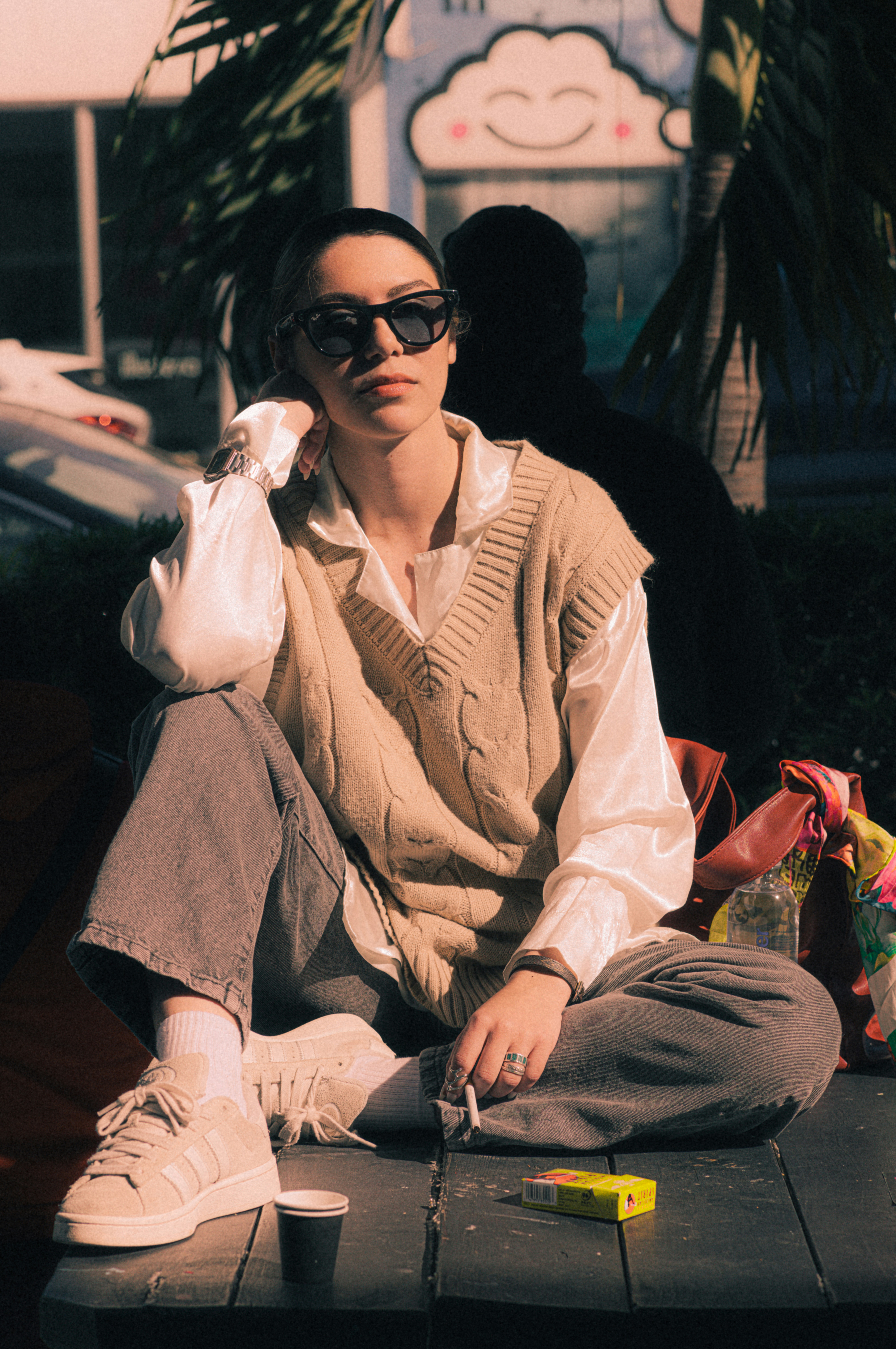 A man sitting on the ground next to a car