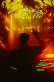 A blurry photo of a person dancing at a concert