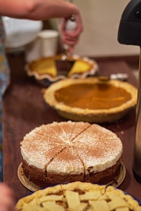 A table topped with cakes and pies covered in powdered sugar