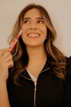 A woman holding a toothbrush in her right hand