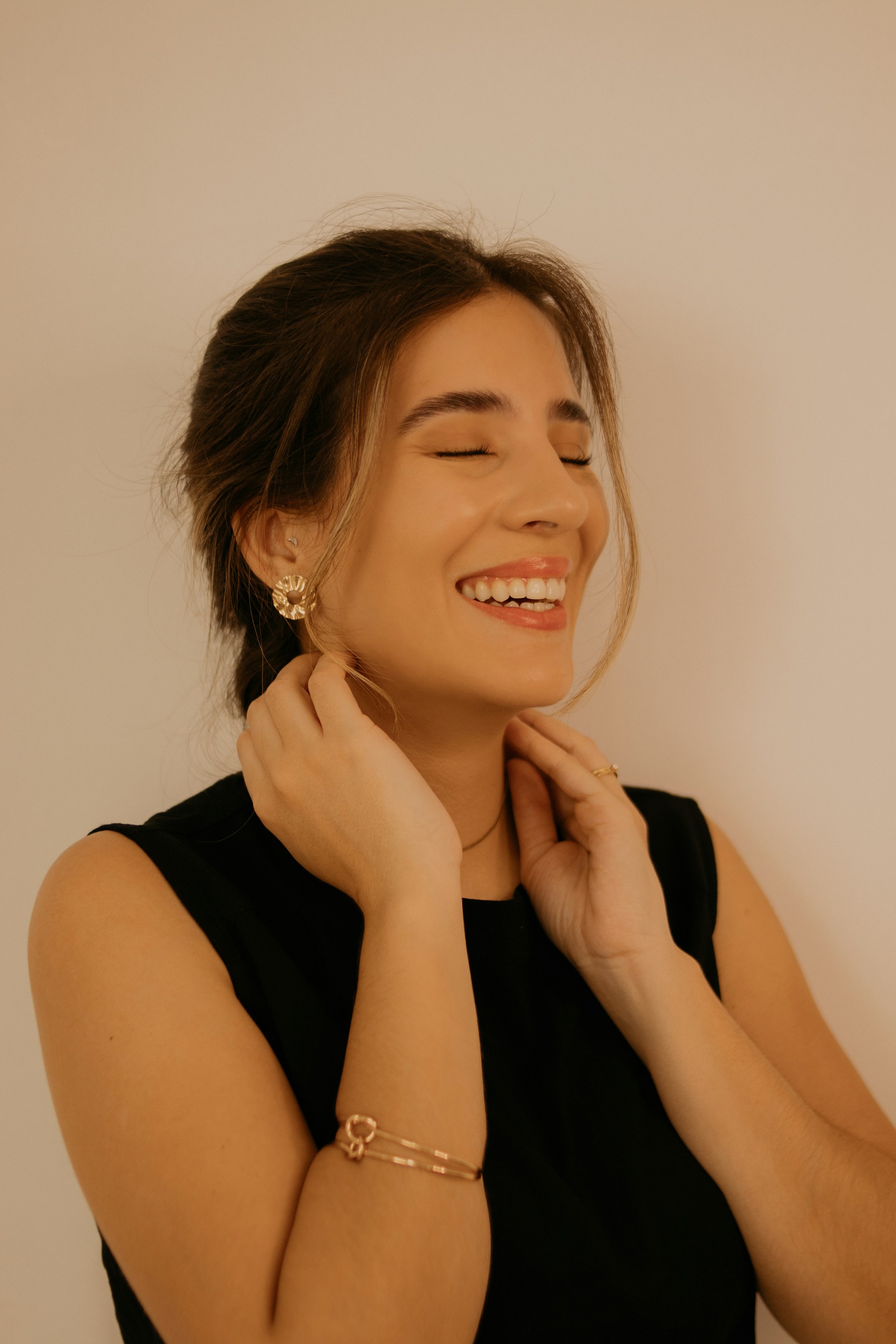 A woman smiling while wearing a black dress