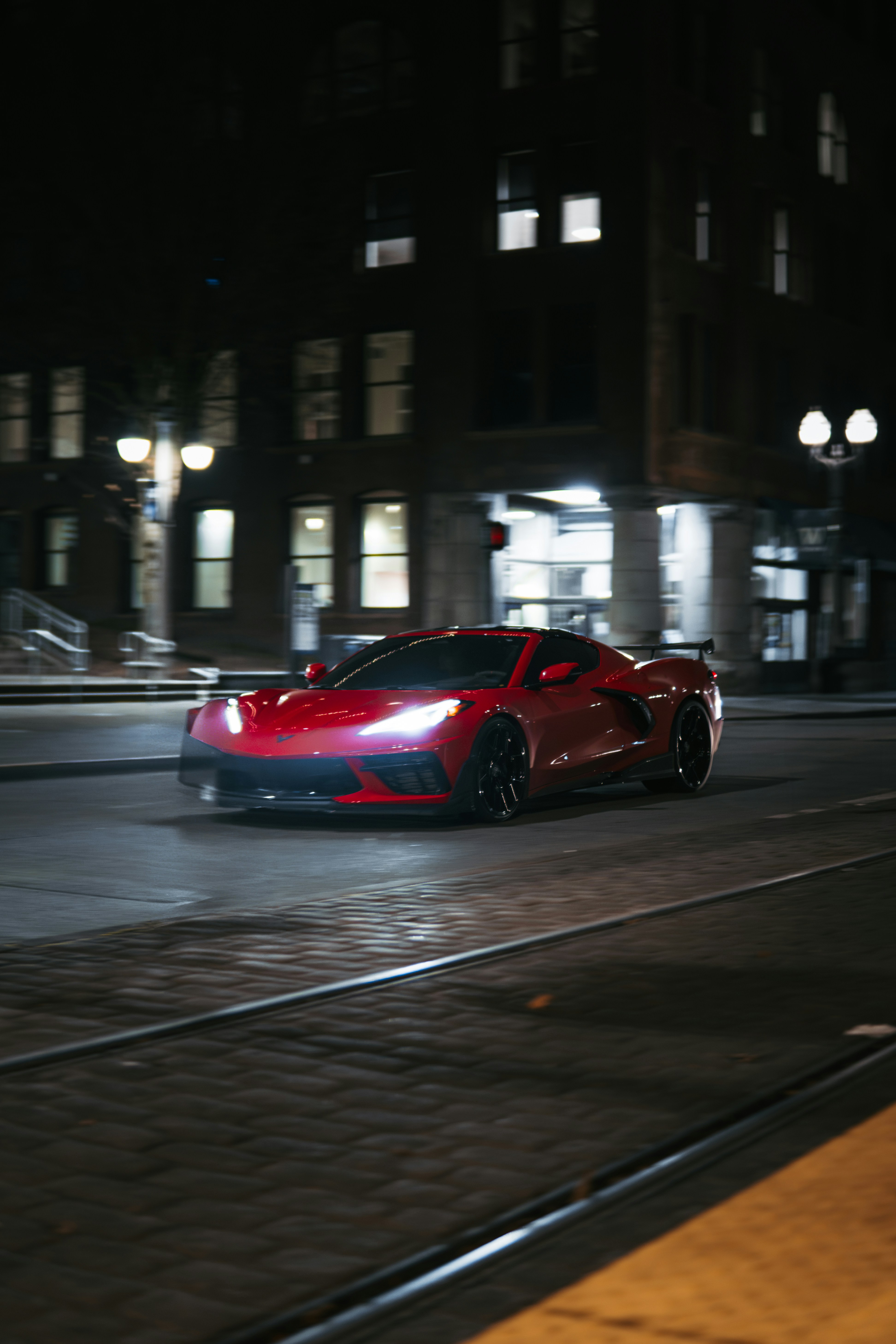 A red sports car driving down a street at night photo – Free Wallpaper ...