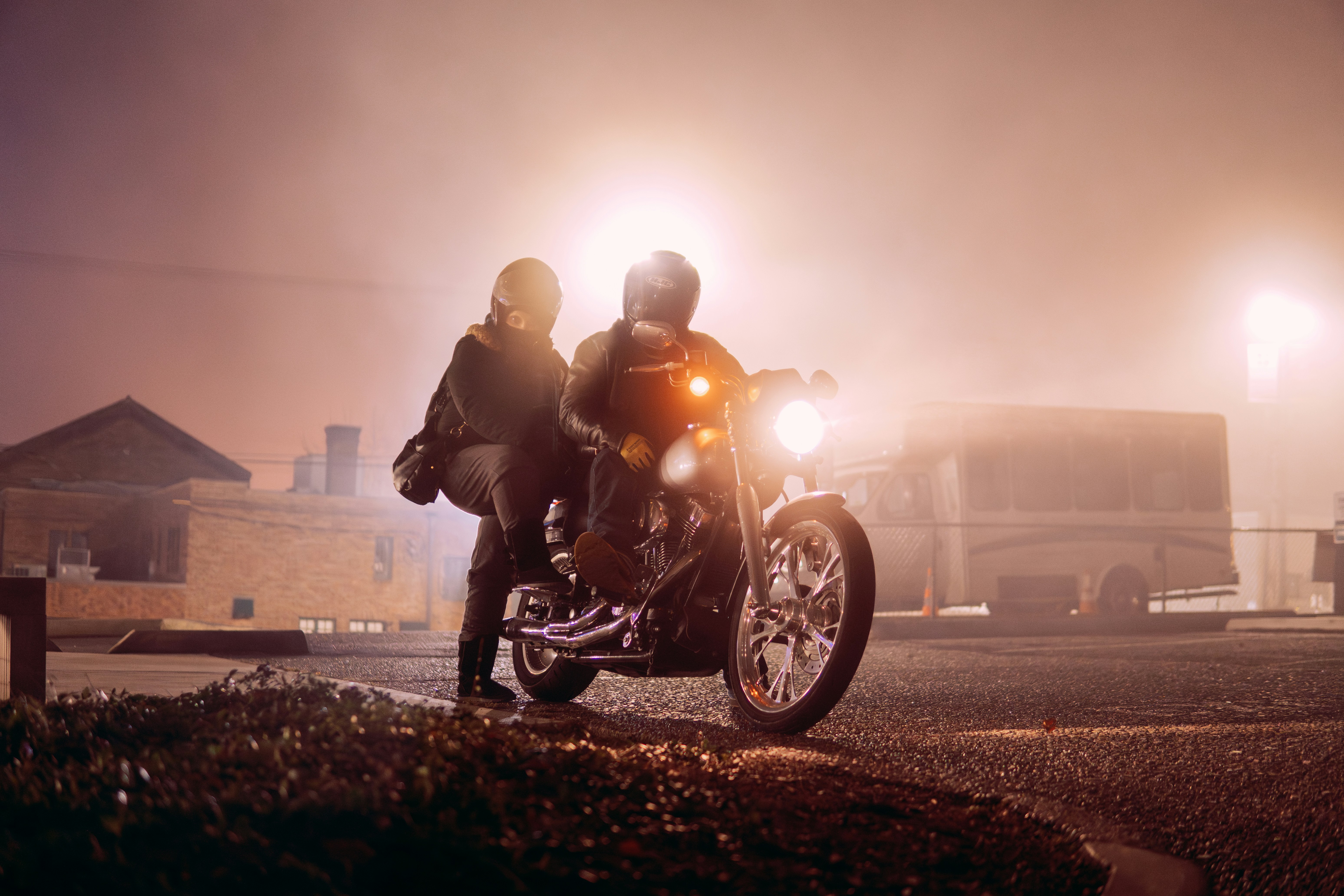 A man and a woman riding a motorcycle at night