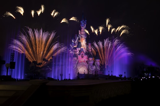 Fireworks are lit up in the night sky above a castle