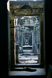 A doorway in a stone building with a cat laying on the floor