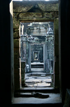 A doorway in a stone building with a cat laying on the floor