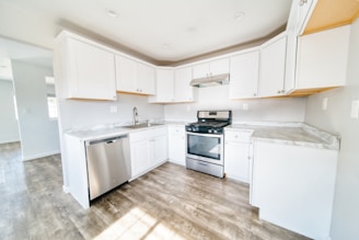 A kitchen with white cabinets and stainless steel appliances