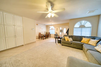 A living room filled with furniture and a ceiling fan