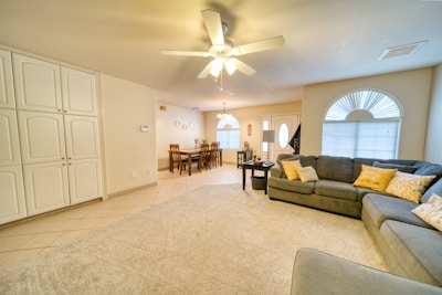 A living room filled with furniture and a ceiling fan