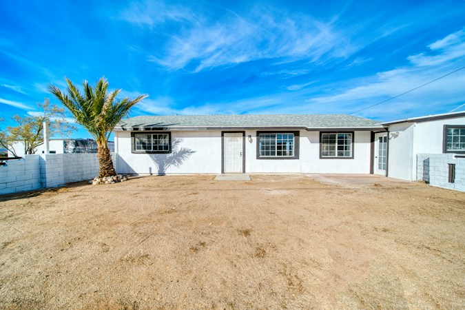 Single-story desert home with a palm tree in front, the kind of resale house sitting longer on the Las Vegas market
