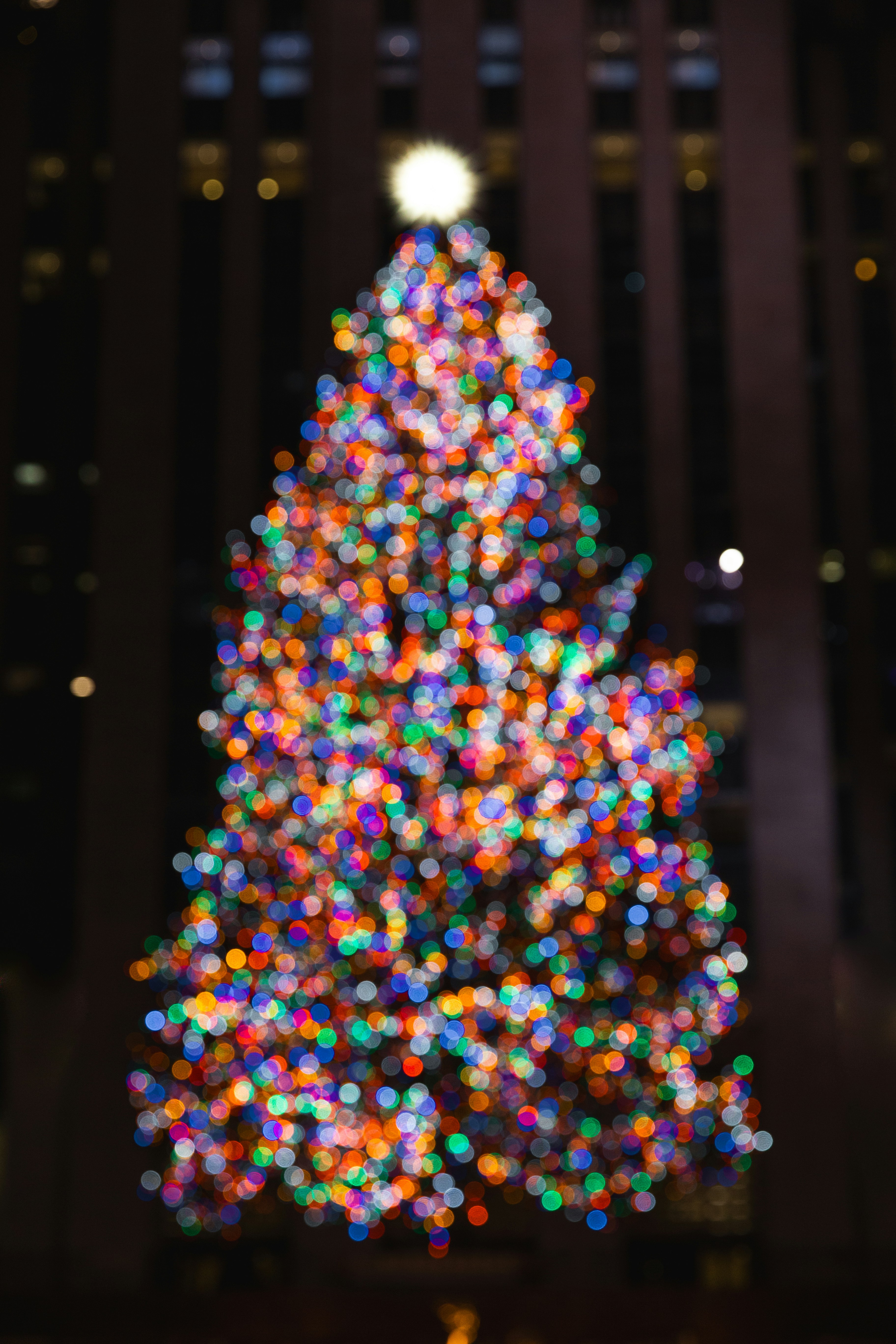 Un árbol de Navidad brillantemente iluminado en una ciudad por la noche