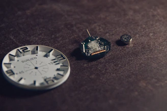 A watch and a pair of earrings on a table