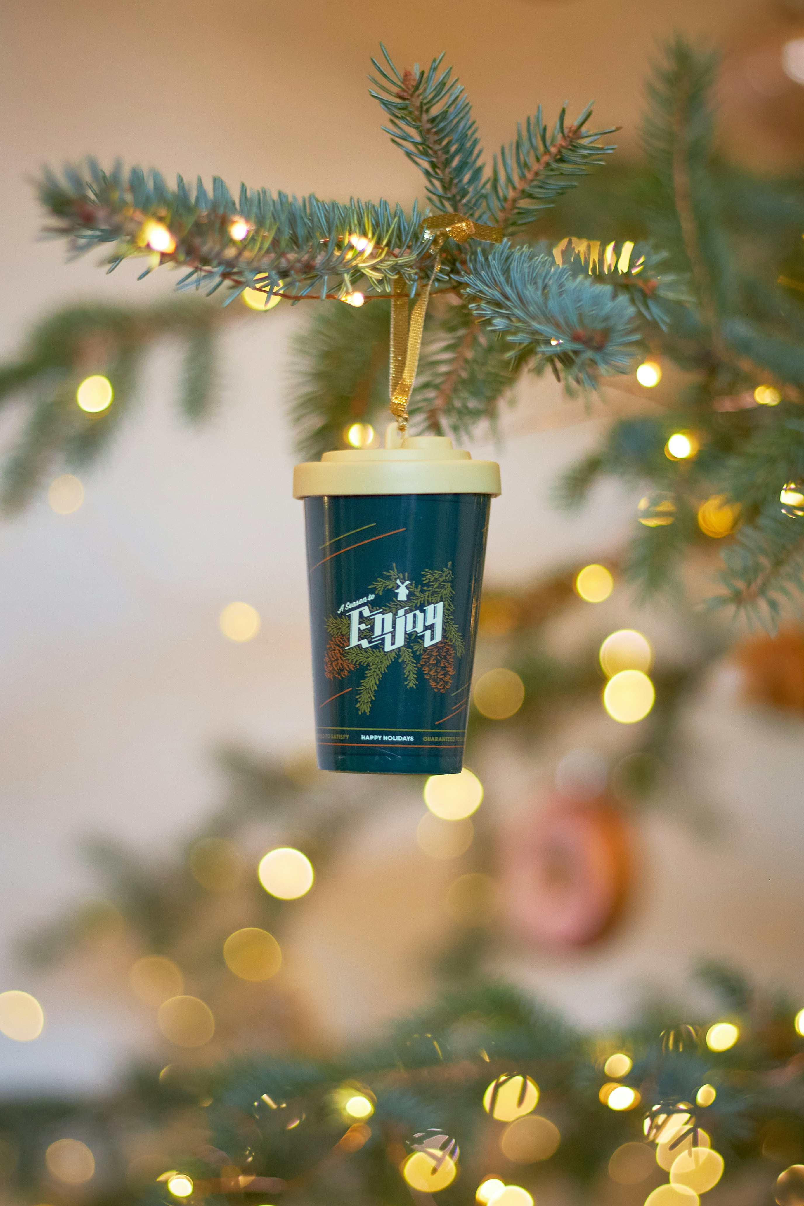 Ornamen cangkir kopi tergantung di pohon natal