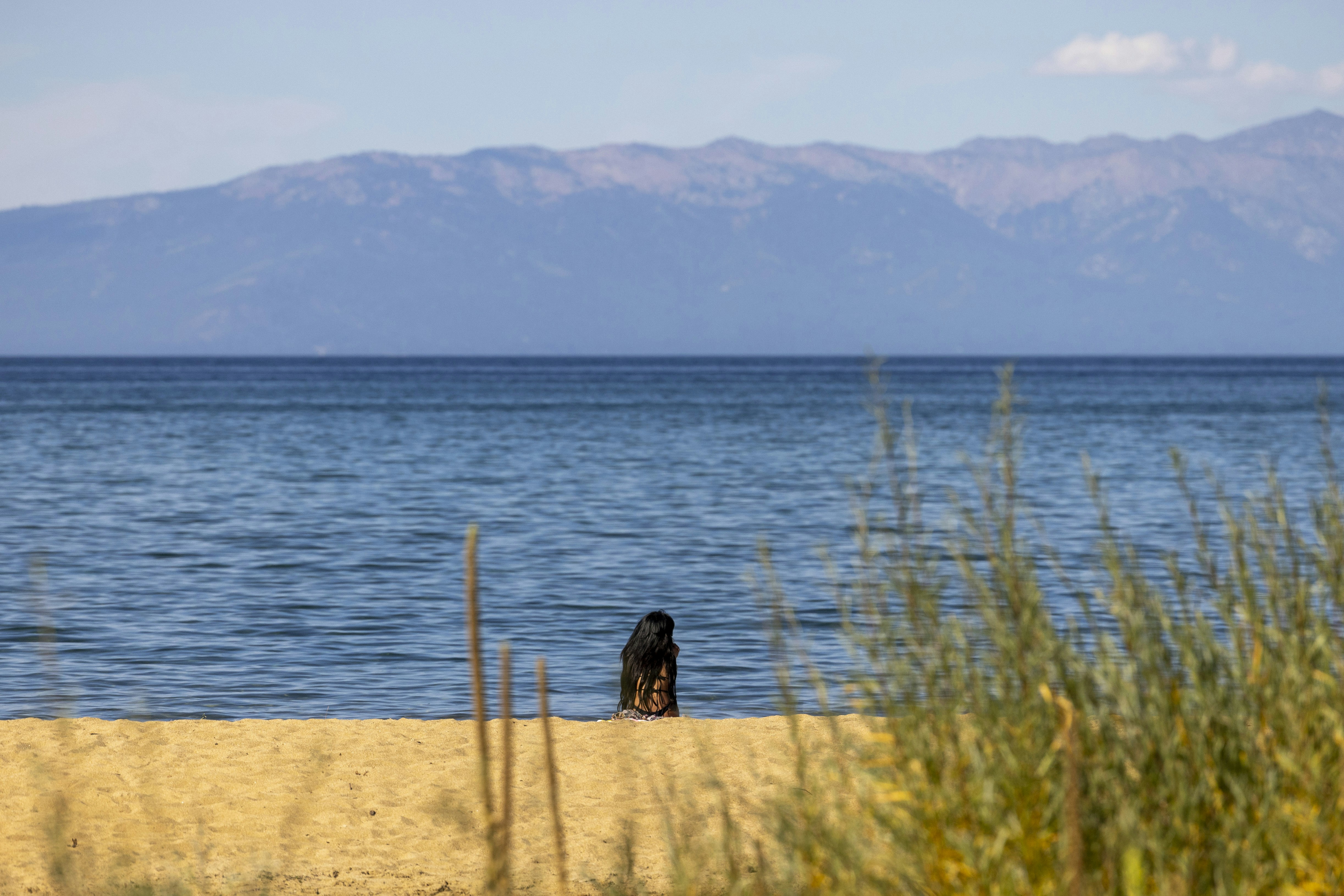 A person sitting on a beach near the ocean