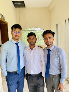 A group of three men standing next to each other