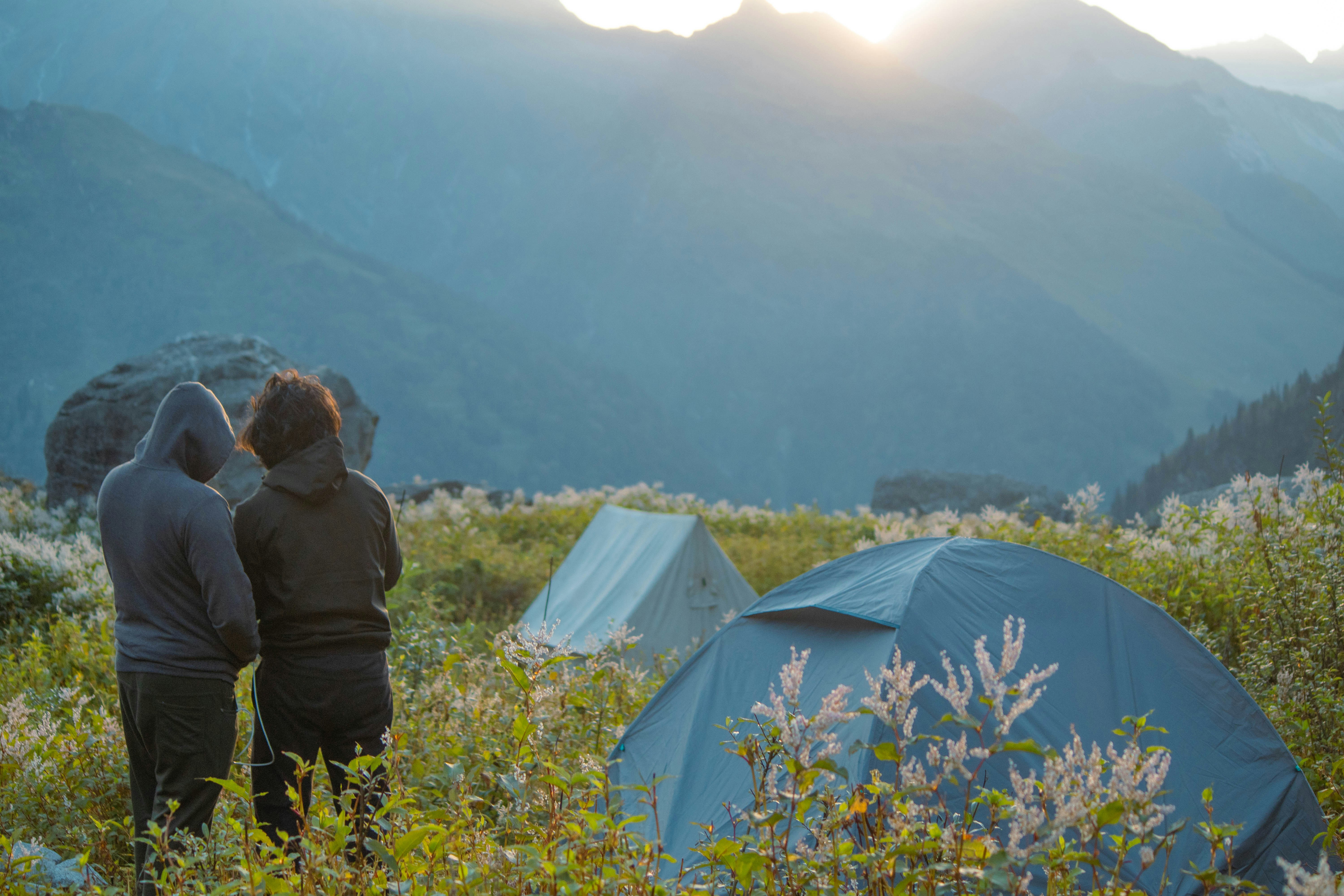 A couple of people standing next to a tent