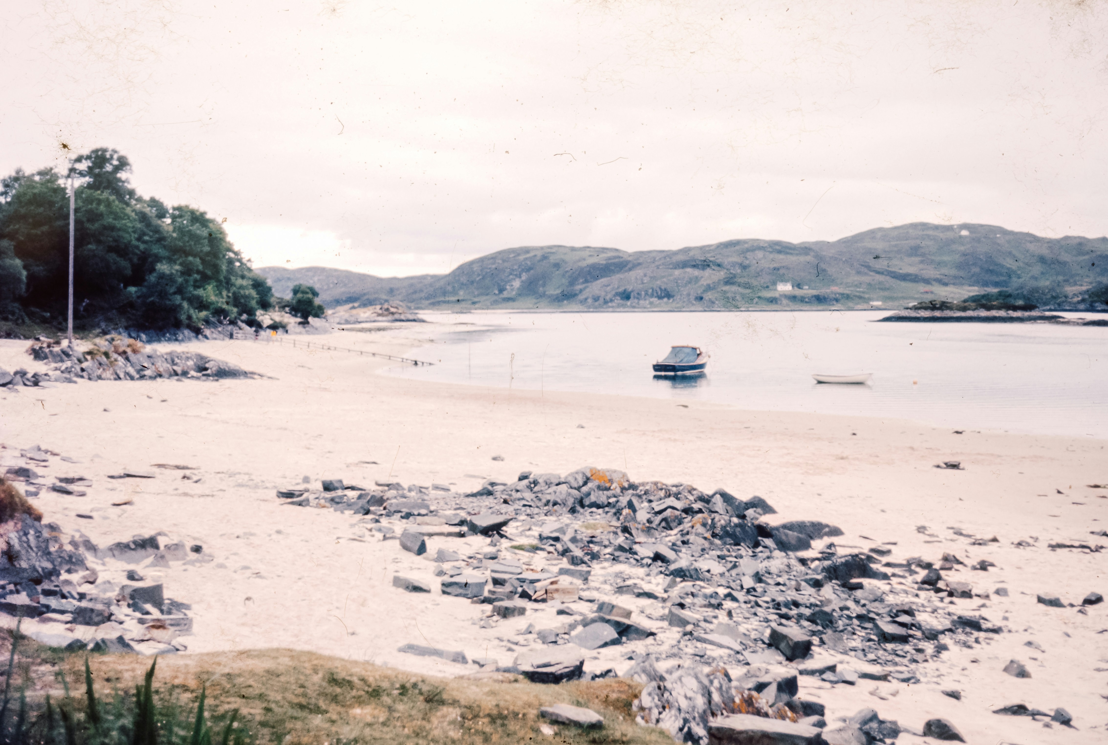 A sandy beach with a boat in the water