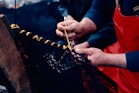 Two people working on a piece of fabric