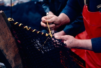 Two people working on a piece of fabric