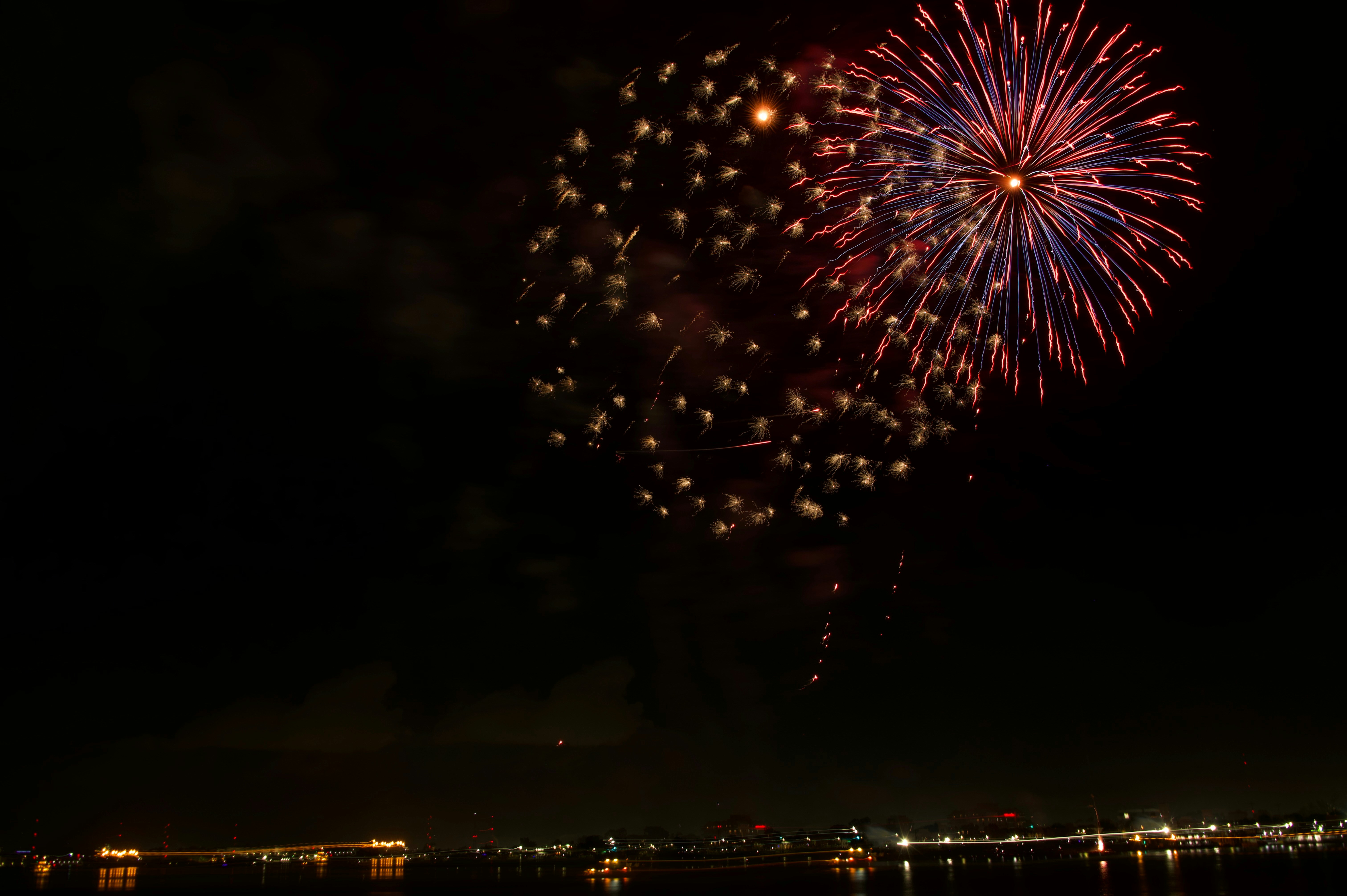 A firework display in the night sky over a body of water
