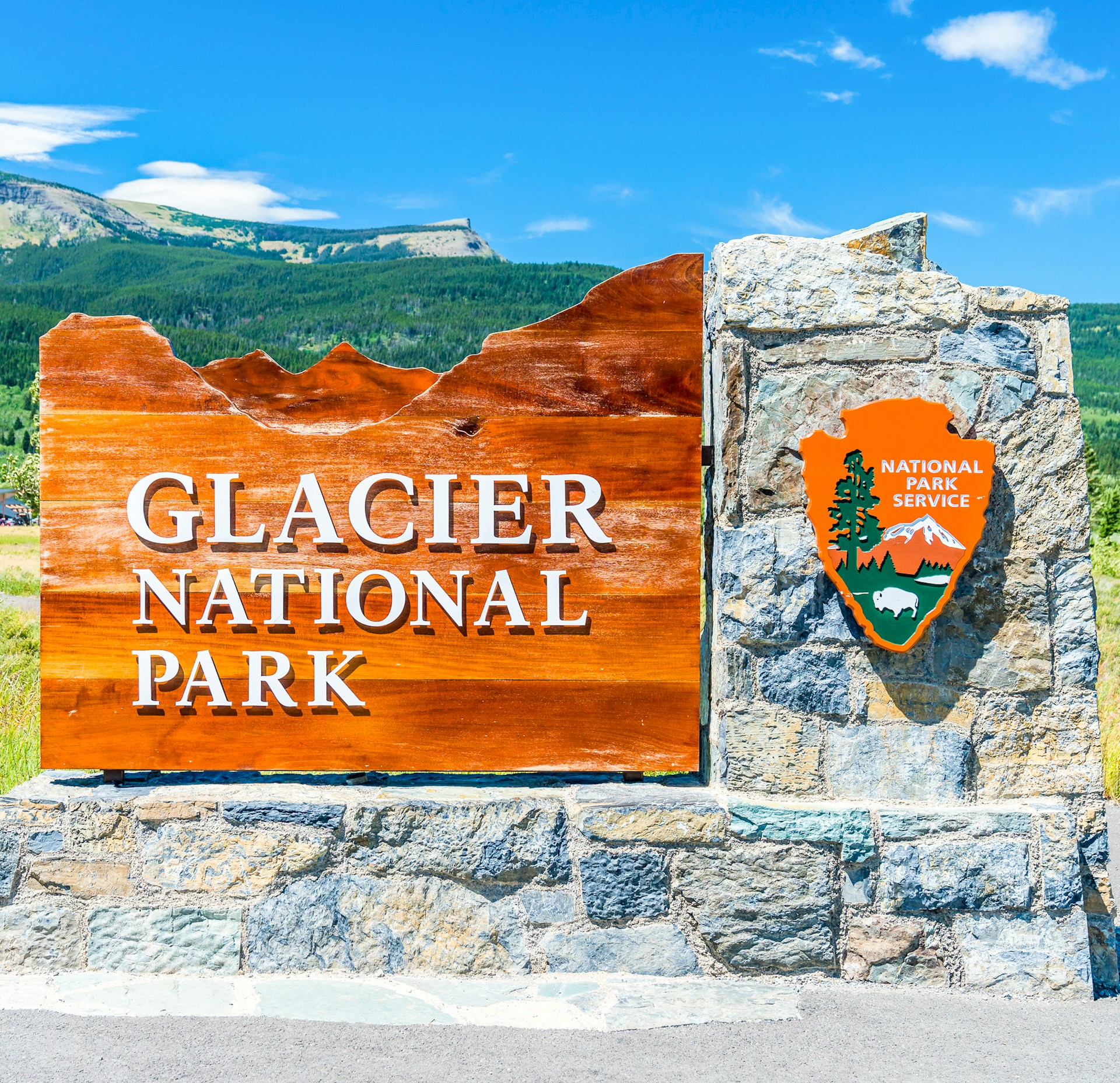 A sign for glacier national park in the mountains